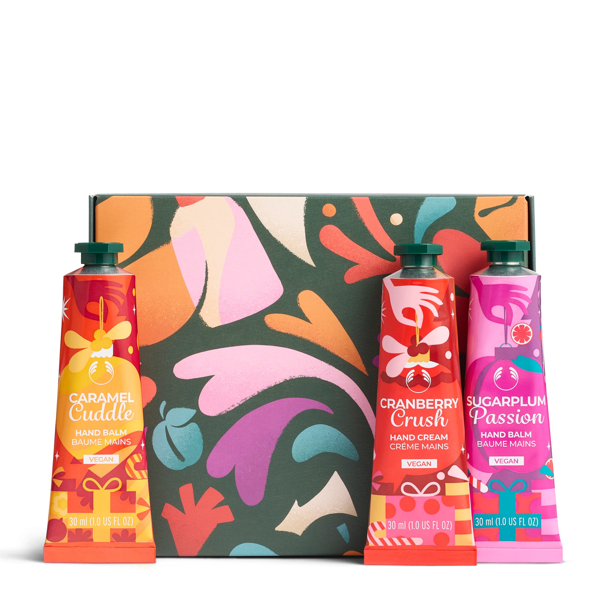 Three hand care products in front of a colorful abstract-patterned box