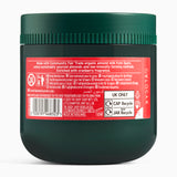 Back of a green jar with a red label on a white background