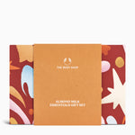 Gift set packaging for 'Almond Milk Essentials' by The Body Shop with a colorful design on a white background.
