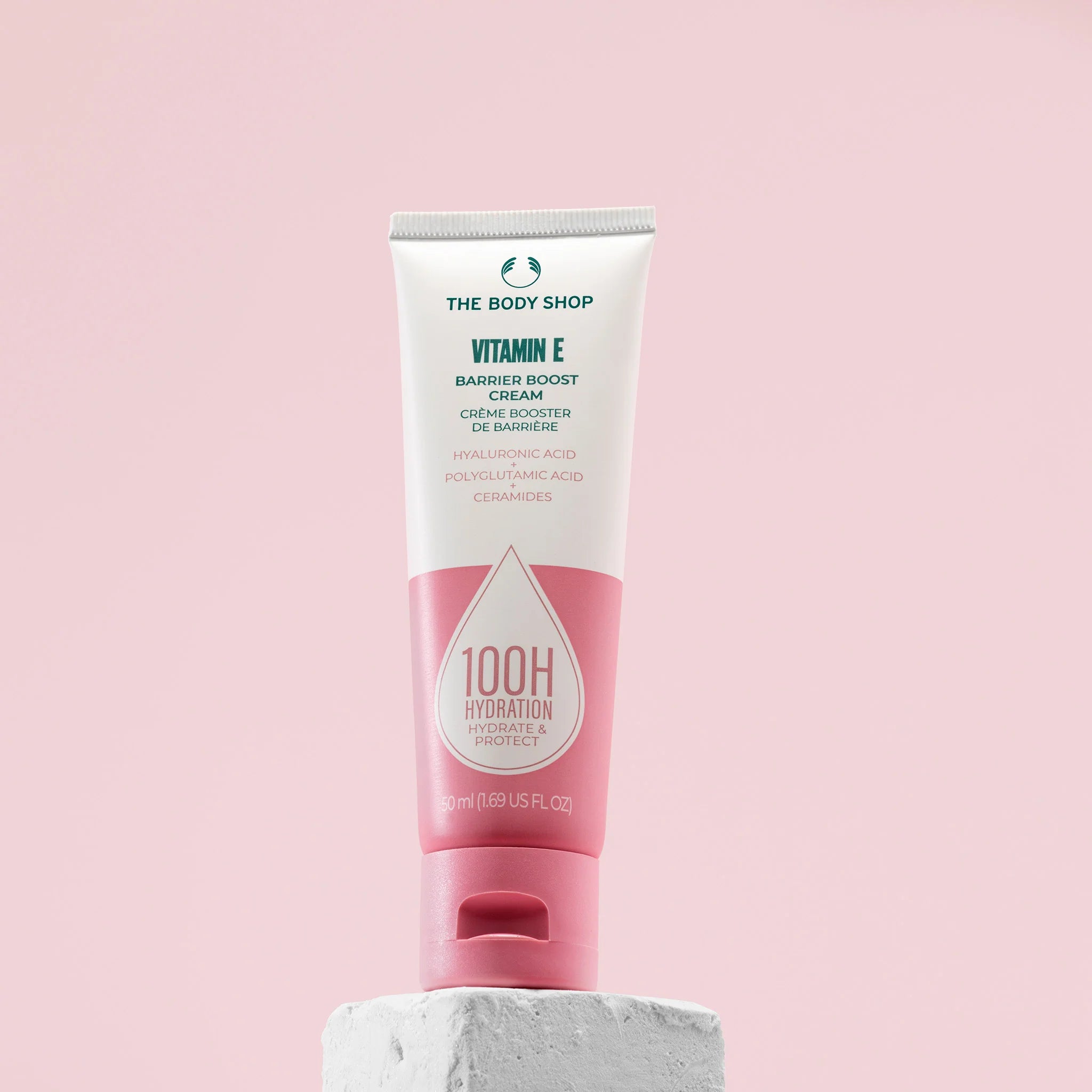 Tube of The Body Shop Vitamin E Barrier Boost Cream on a pink background
