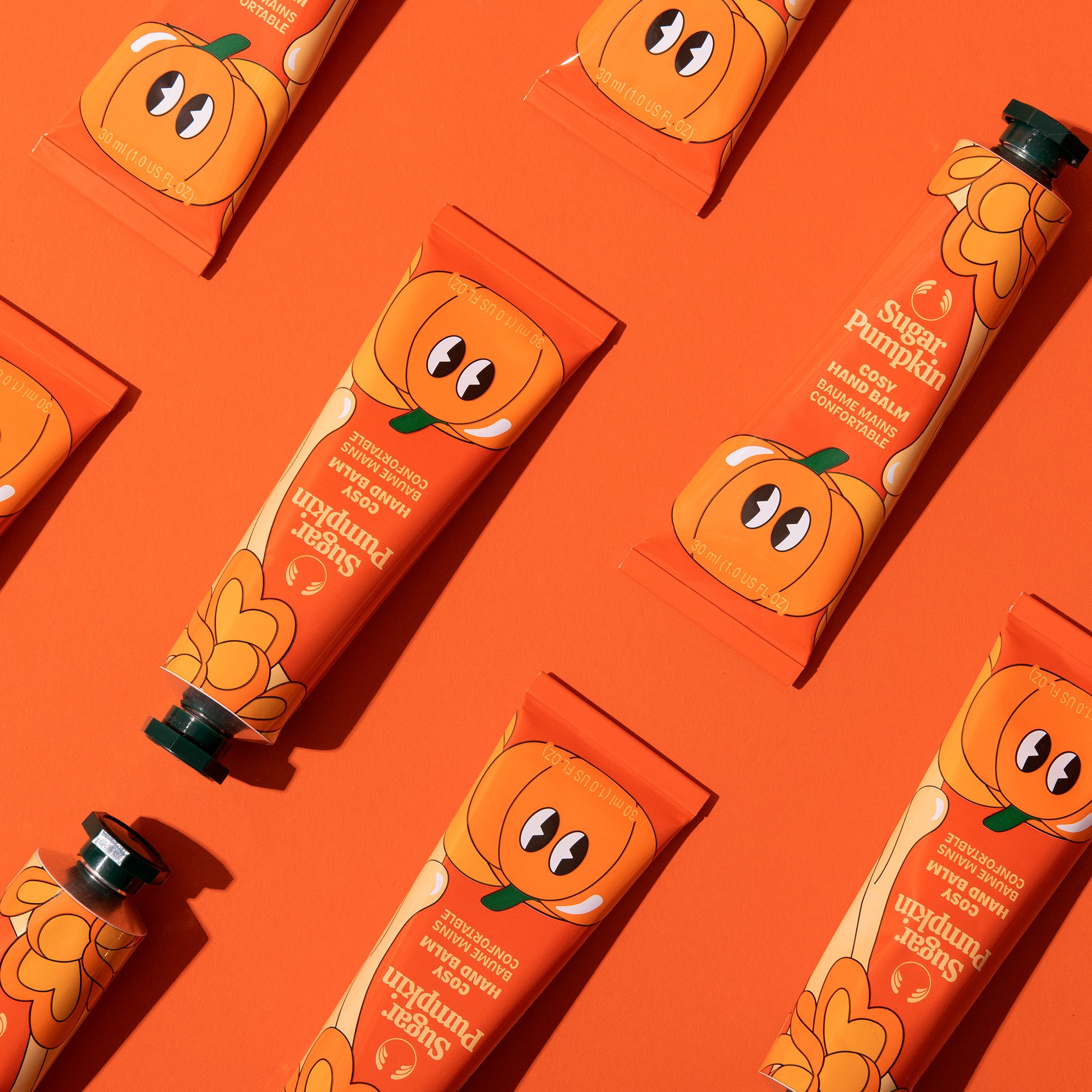 Pumpkin-themed hand cream packaging on an orange background