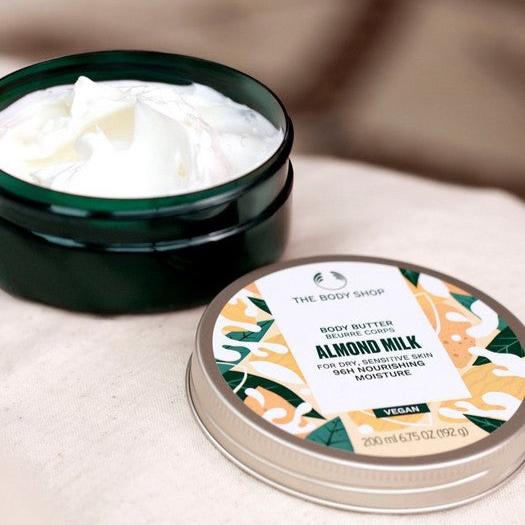 The body shop almond milk body butter product opened and on a white background