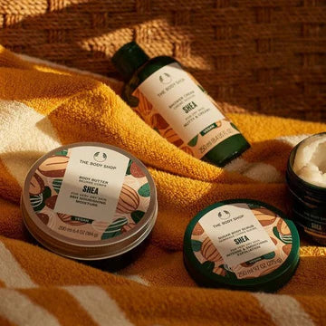 The body shop shea products laid out on an orange towel.