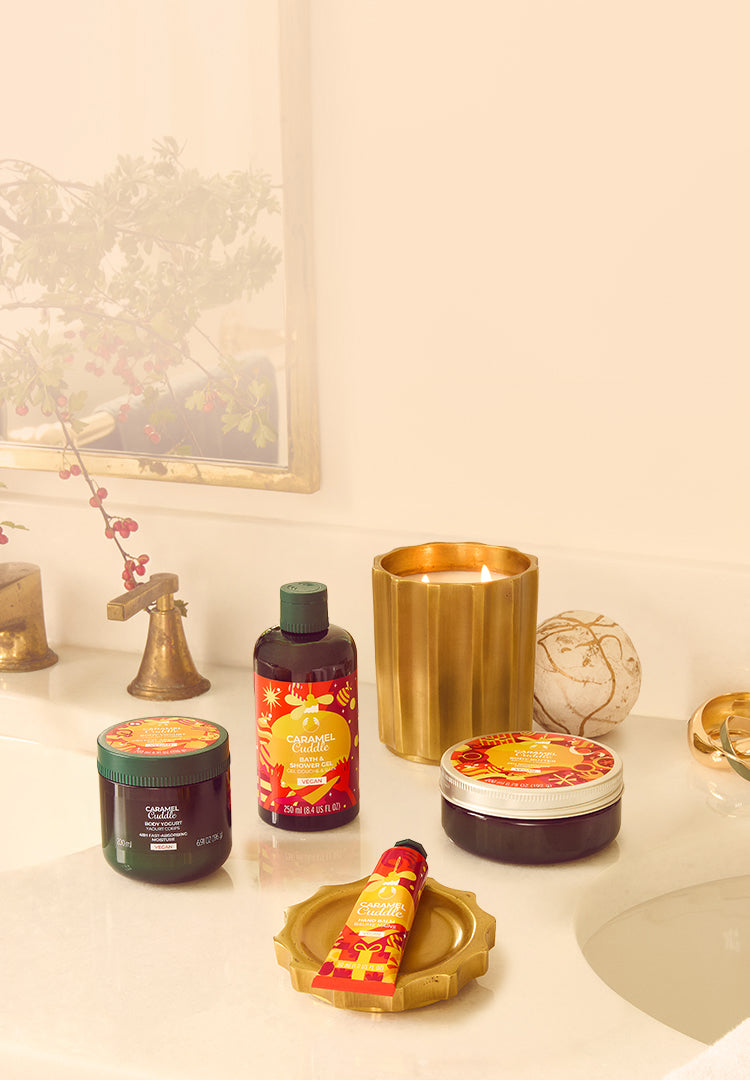 Bathroom counter with various beauty products including bottles, jars, and a candle.