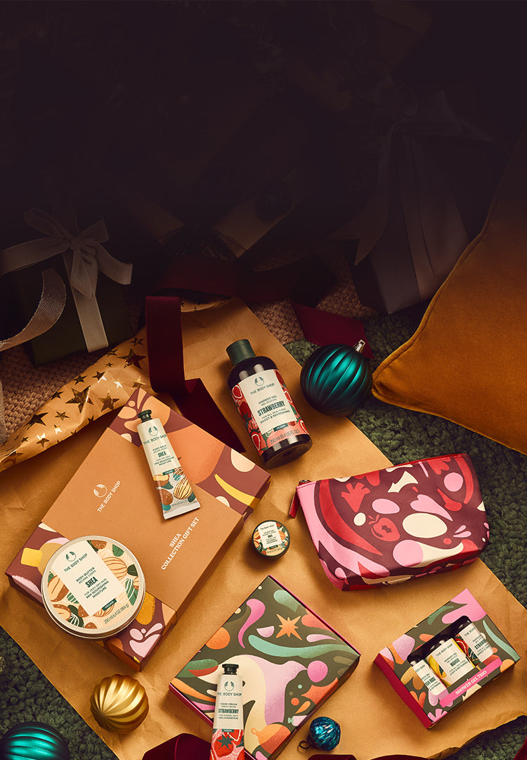 Collection of beauty products including a red pouch, bottles, and boxes on a textured surface with decorative elements.