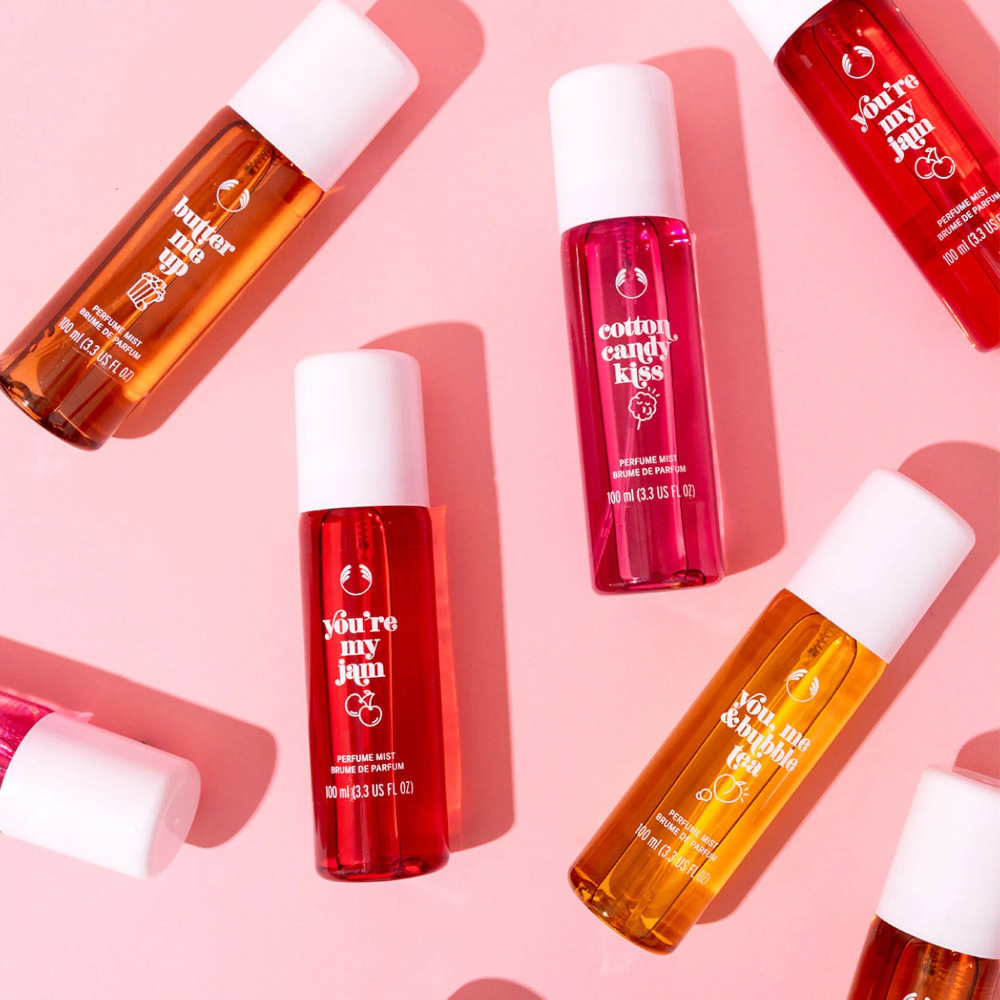 Various Perfume Mist bottles on a pink background