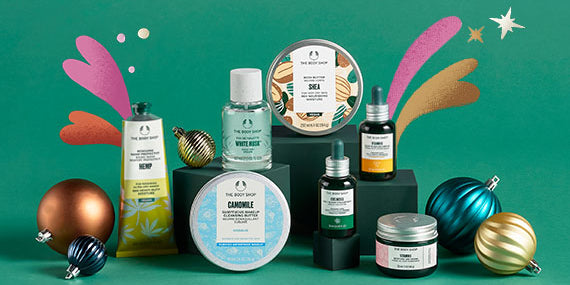Collection of skincare products and festive ornaments on a green background