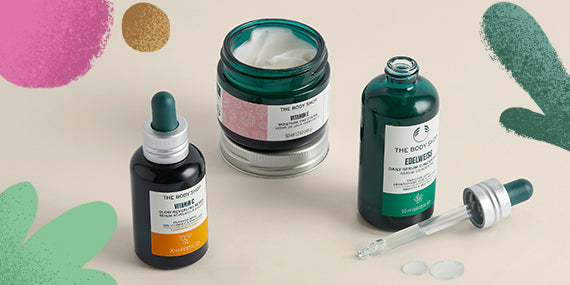 Skincare products including bottles and a jar on a beige background with decorative elements.