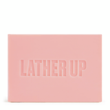 Pink bar of soap with 'LATHER UP' text on a white background