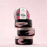 Stack of The Body Shop British Rose body butters on a pink background