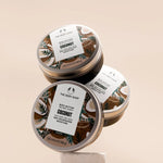 Three tins of The Body Shop Coconut body butter on a beige background