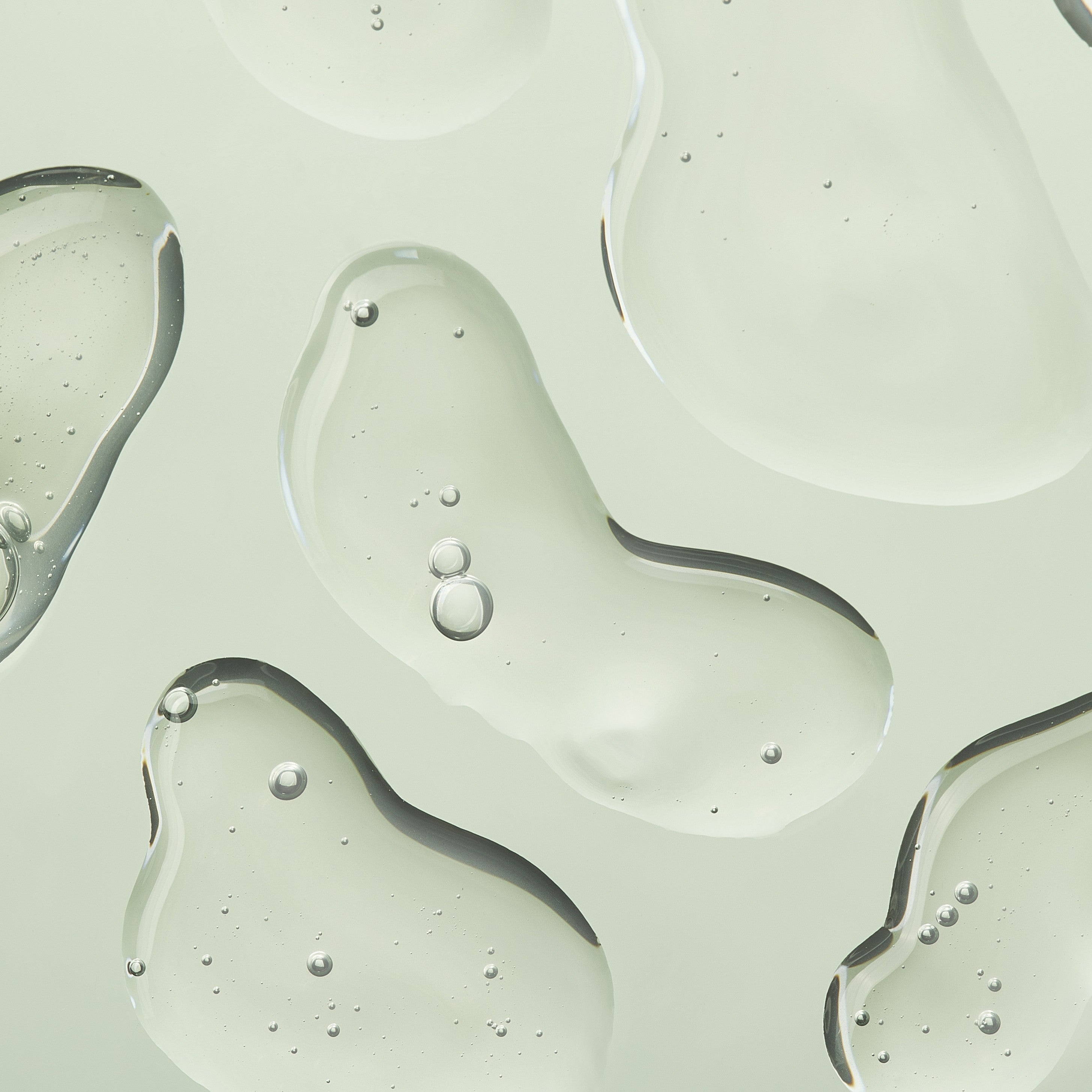 Close up swatch of white liquid on light green background