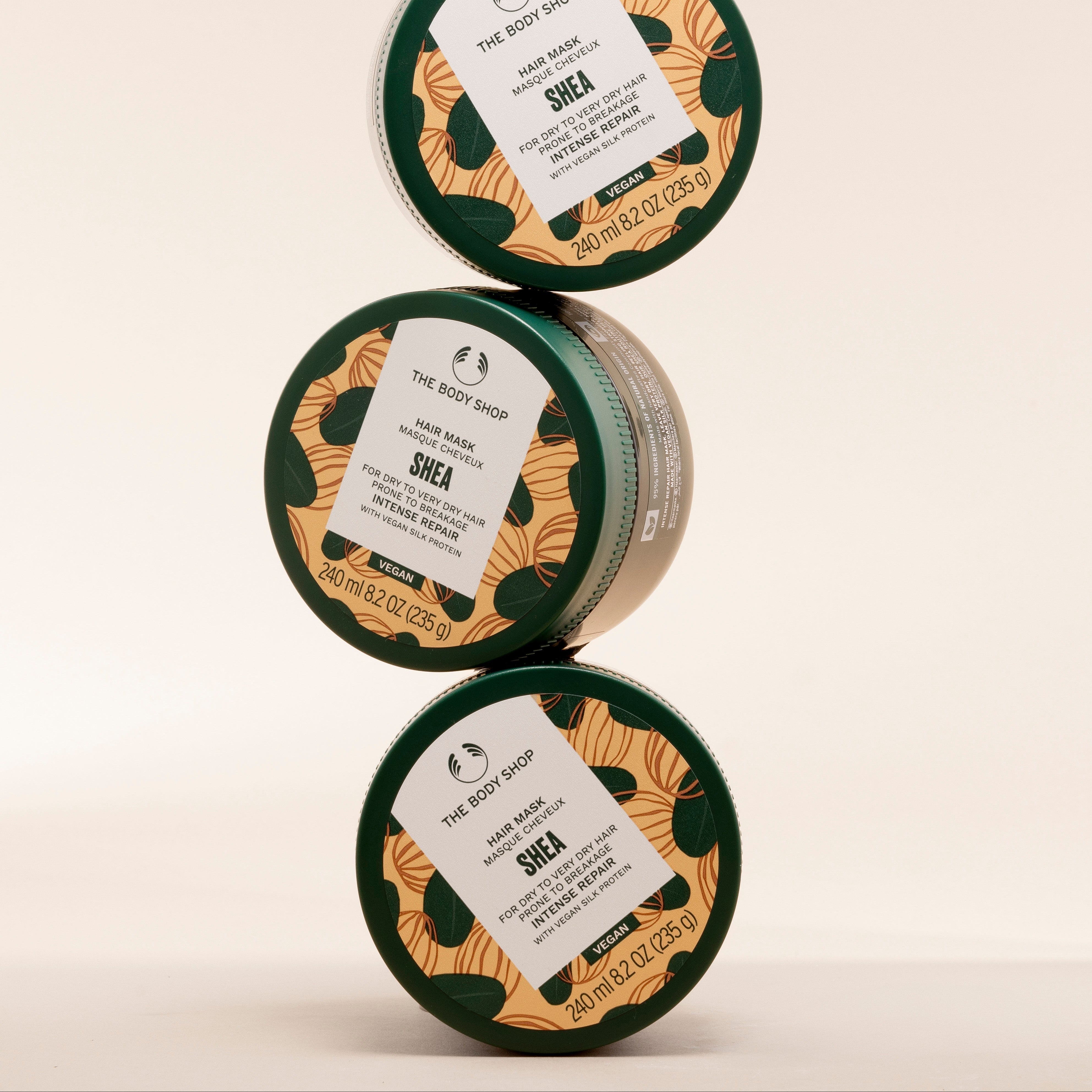 Three containers of The Body Shop Shea Butter on a beige background