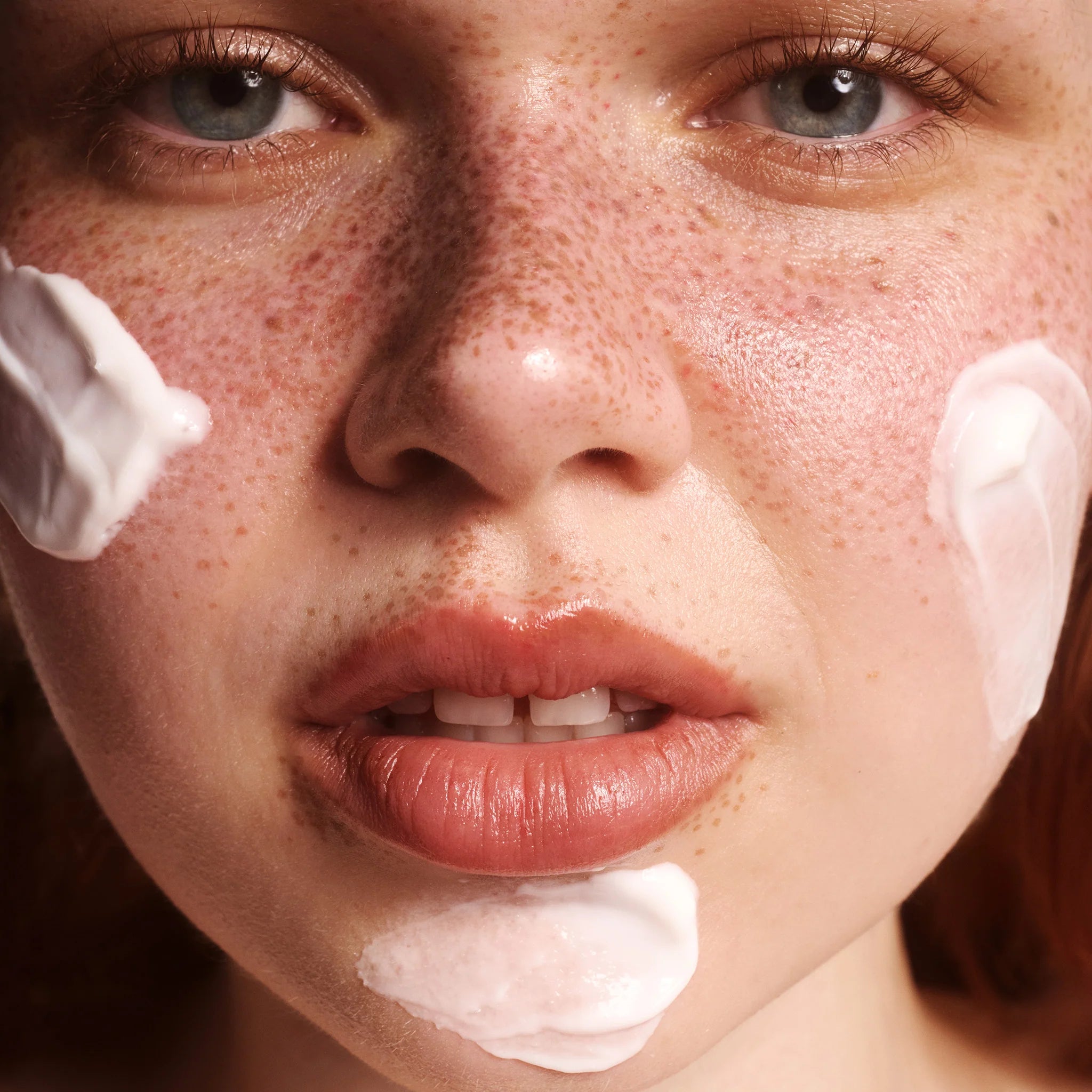 Close-up of a person's face with cream on their cheeks