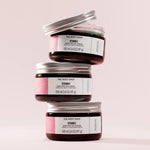 Three jars of The Body Shop Vitamin E Moisture Day Cream stacked on a light pink background