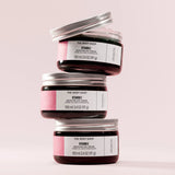 Three jars of The Body Shop Vitamin E Moisture Day Cream stacked on a light pink background