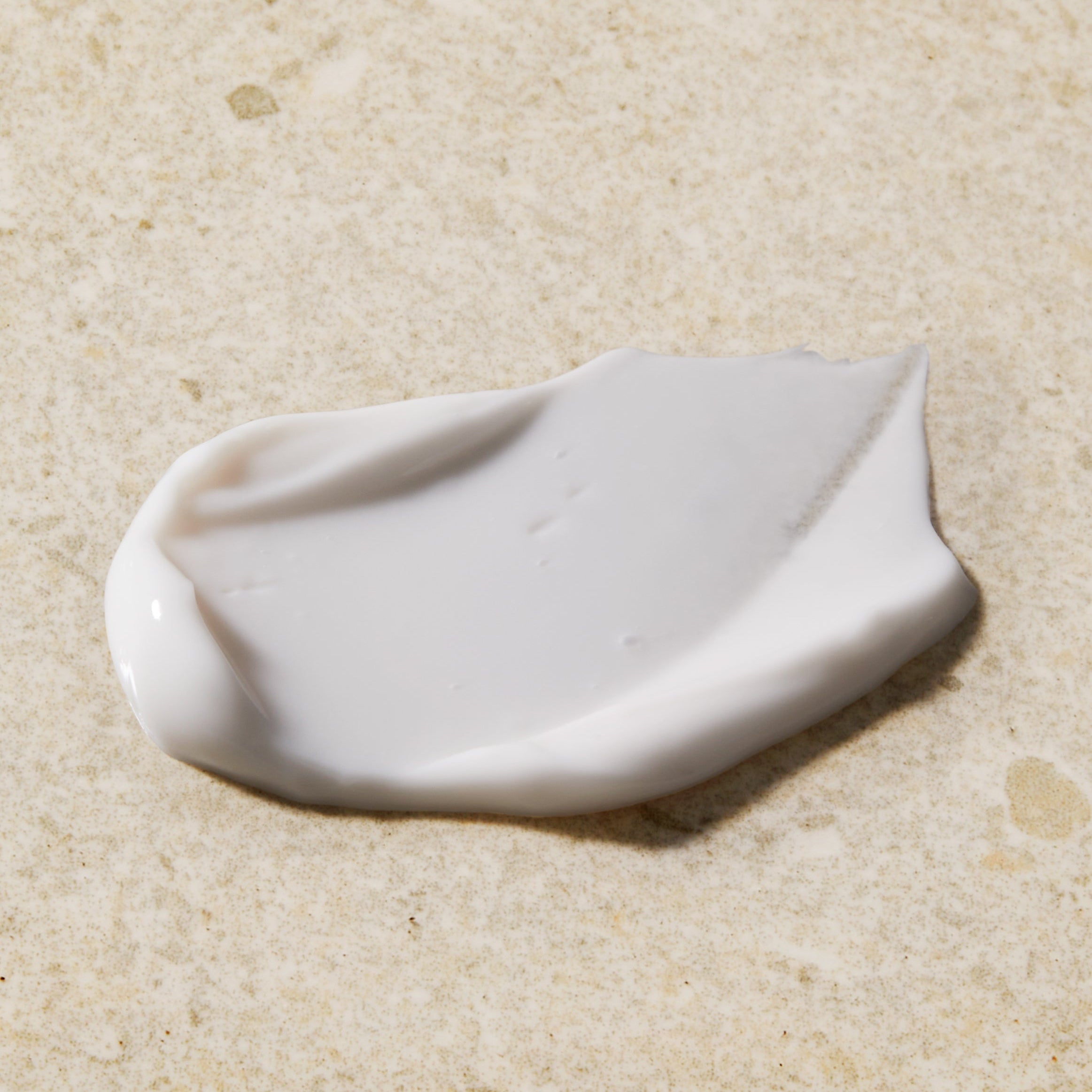 White ceramic leaf-shaped object on a beige surface