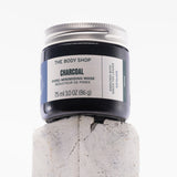 Jar of The Body Shop Charcoal Pore-Minimising Mask on a textured white background