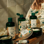 The Body Shop Shea product set on a wooden surface with a tiled wall background