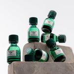 Green bottles with black caps on a concrete block against a white background