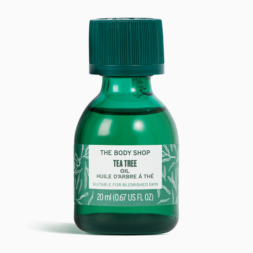 Green bottle of The Body Shop Tea Tree oil on a white background