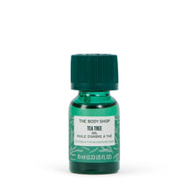 Green bottle of The Body Shop Tea Tree oil on a white background