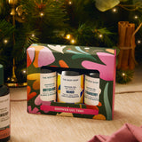 Shower gel trio set in a decorative box with a Christmas tree in the background