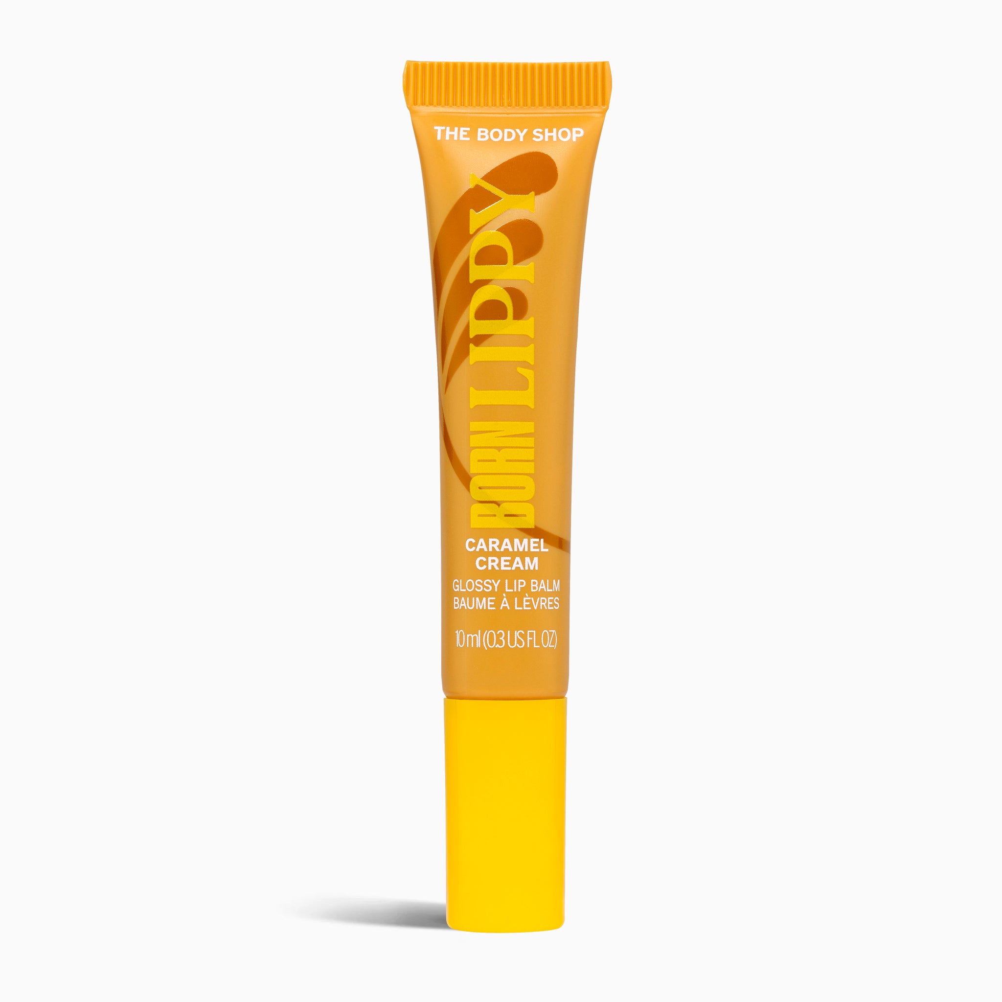 Tube of The Body Shop lip balm with caramel color on a white background