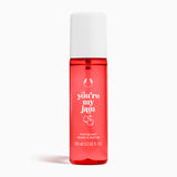 Red perfume mist bottle with white cap and text on a white background