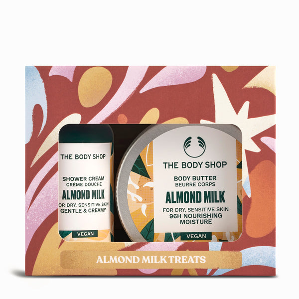The Body Shop Almond Milk treats set with shower cream and body butter on a colorful box background.
