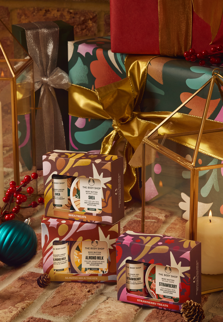 Gift boxes with decorative ribbons and holiday-themed packaging on a rustic surface.