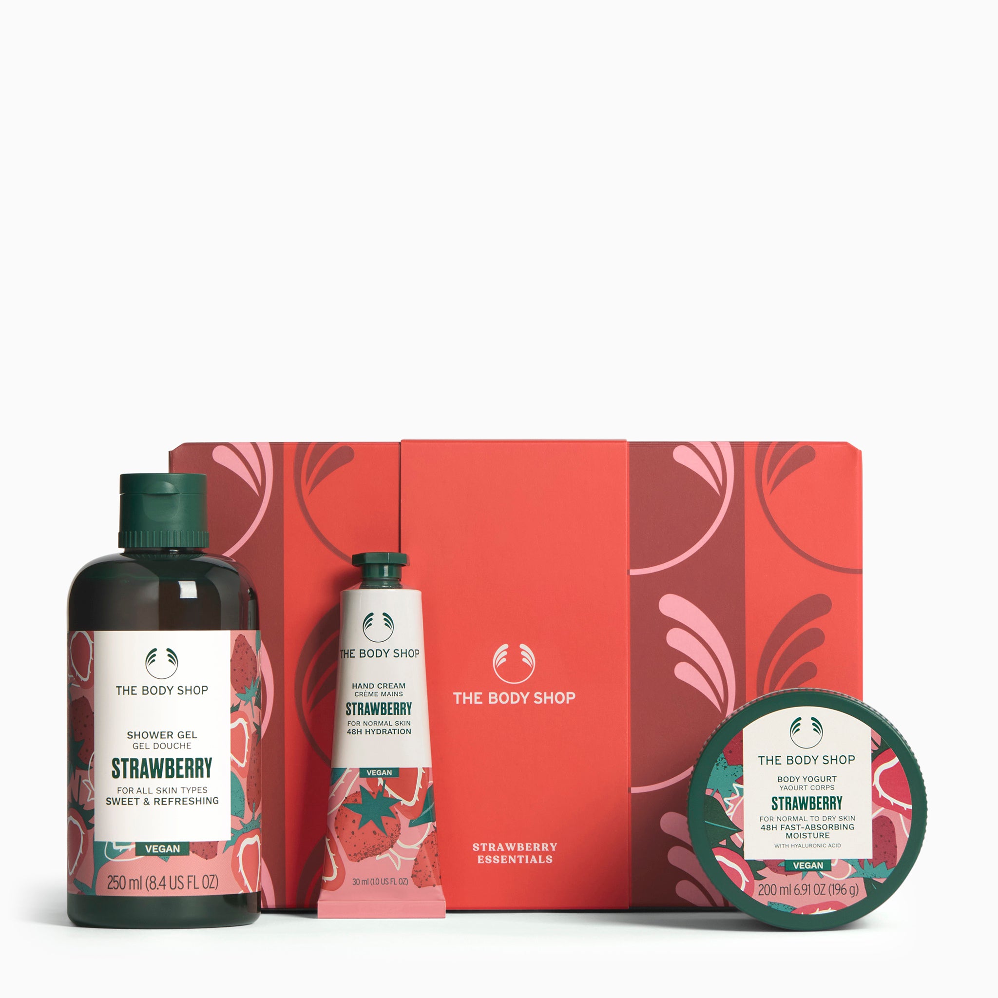 The Body Shop Strawberry product set including shower gel, hand cream, and body scrub on a white background.