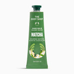 A squeeze tube of The Body Shop Hand Balm in Matcha flavor, featuring a green body with white text and illustrations of matcha leaves and chocolate pieces, set against a plain white background.
