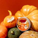 Pumpkin-shaped container with a label on a red background