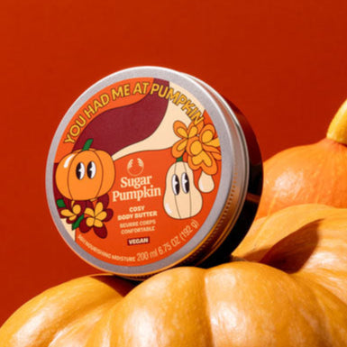 Container of 'Sugar Pumpkin' on a pile of pumpkins with a red background