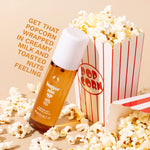 Butter spray bottle with popcorn and a popcorn box on a beige background