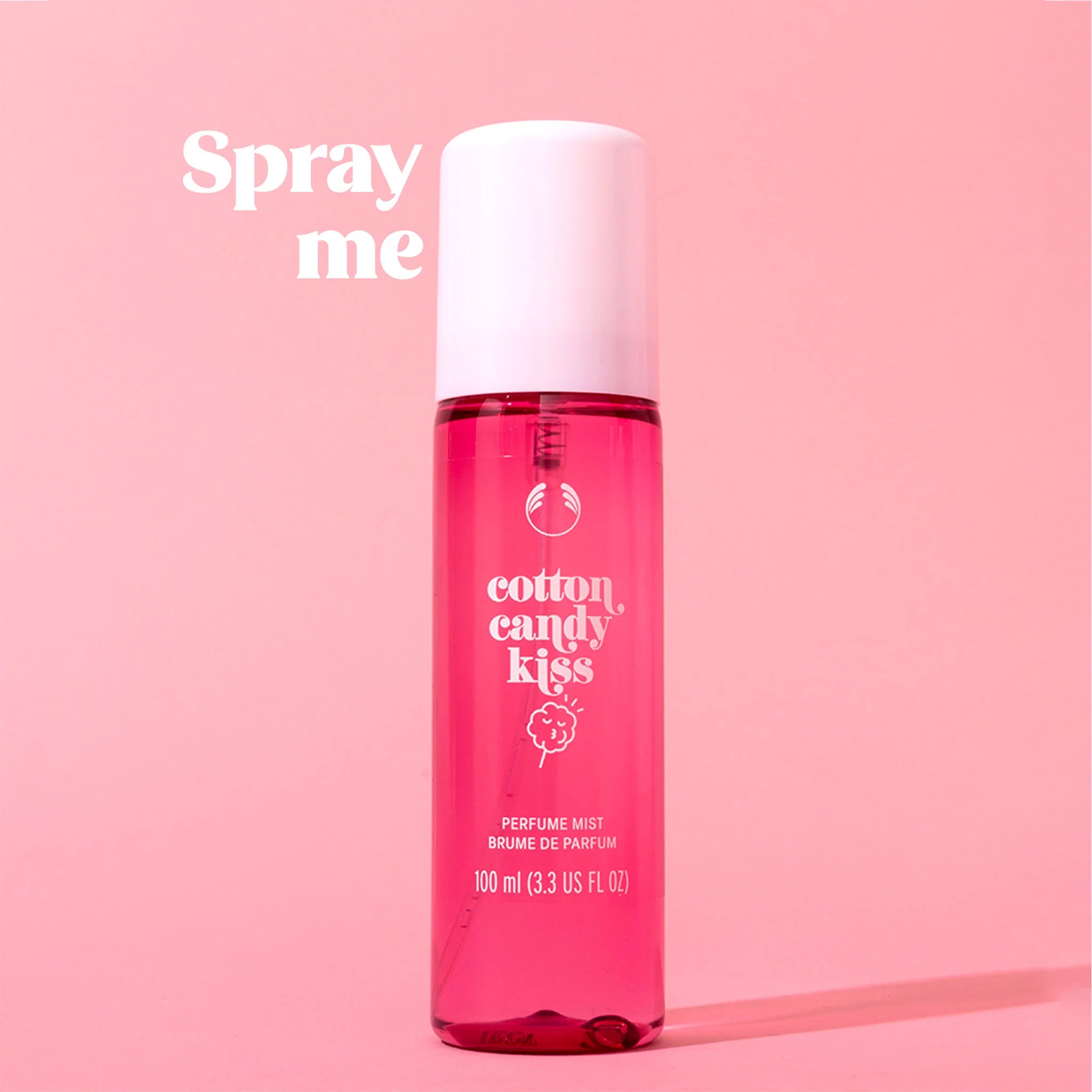 Perfume spray bottle labeled 'cotton candy kiss' on a pink background
