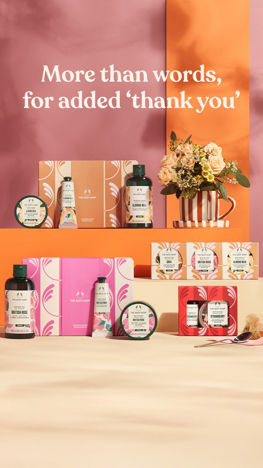 Collection of skincare products and a flower arrangement on a beige surface with a colorful background.