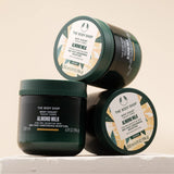 Three jars of The Body Shop Almond Milk Body Yogurt on a beige background