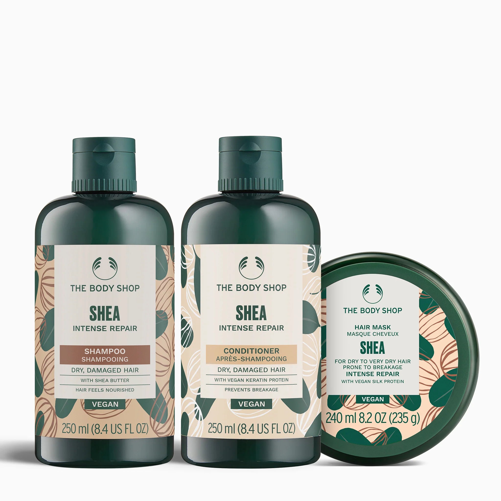 The Body Shop Shea hair care products including shampoo, conditioner, and hair mask on a white background.