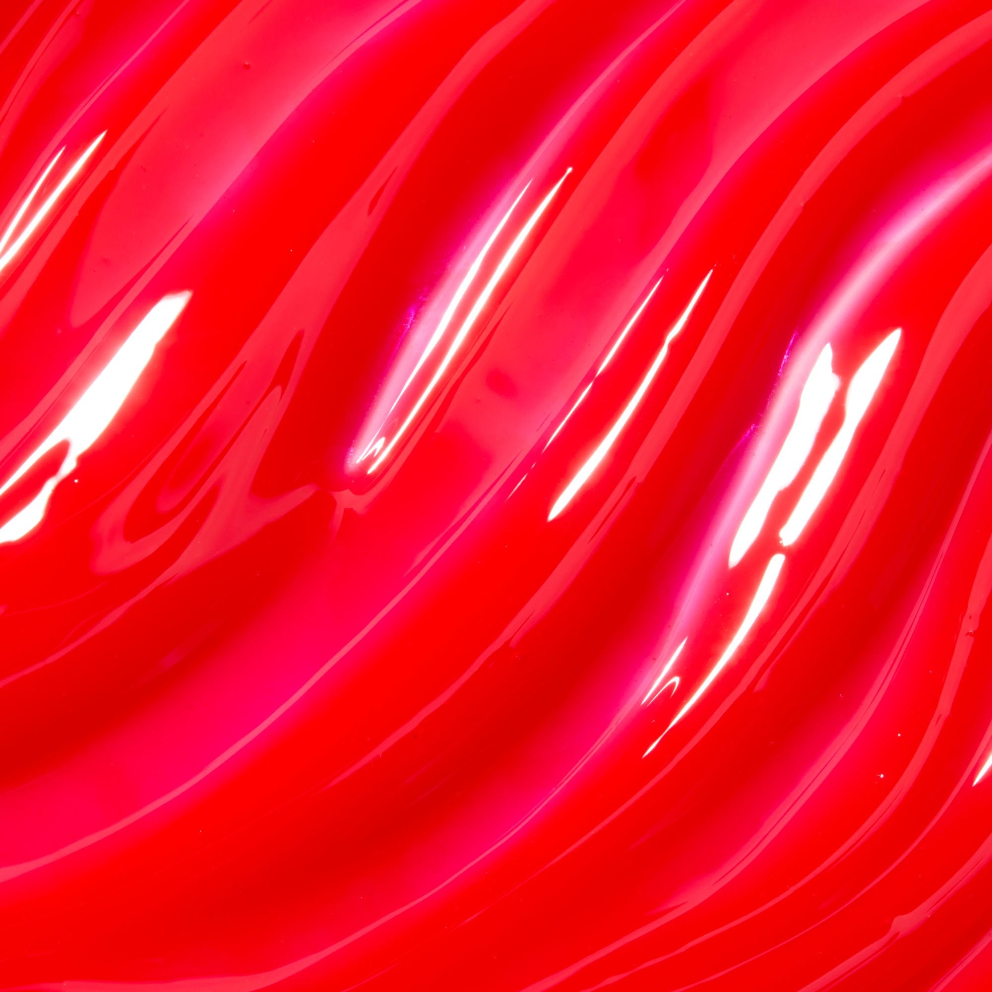 Close-up of red glossy lip gloss with wavy patterns