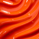 Close-up of smooth, orange- red coloured glossy lip gloss