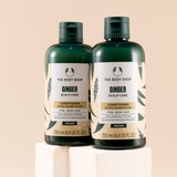 Two bottles of The Body Shop Ginger Scalp Care Conditioner on a beige background