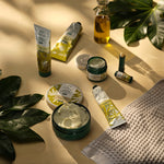 Collection of skincare products on a beige surface with green leaves
