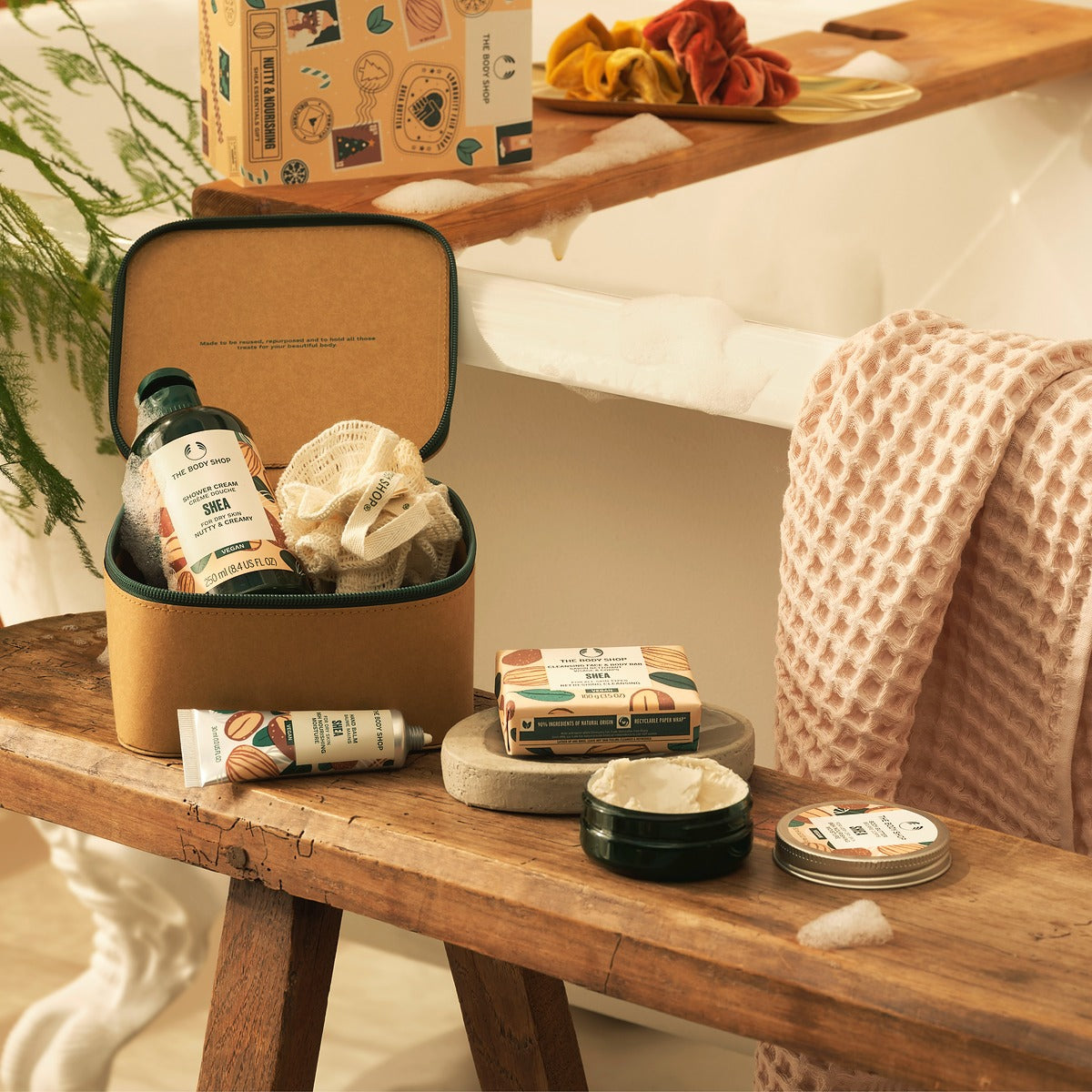 Cosmetic products on a wooden table with a suitcase in the background