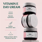 Stack of The Body Shop Vitamin E day cream jars with product benefits on a light pink background