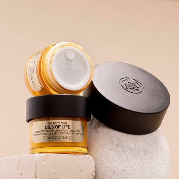 The Body Shop Oils of Life eye cream jar with lid on a neutral background