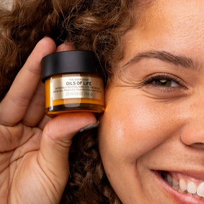 Women holding a jar of oils of life eye cream