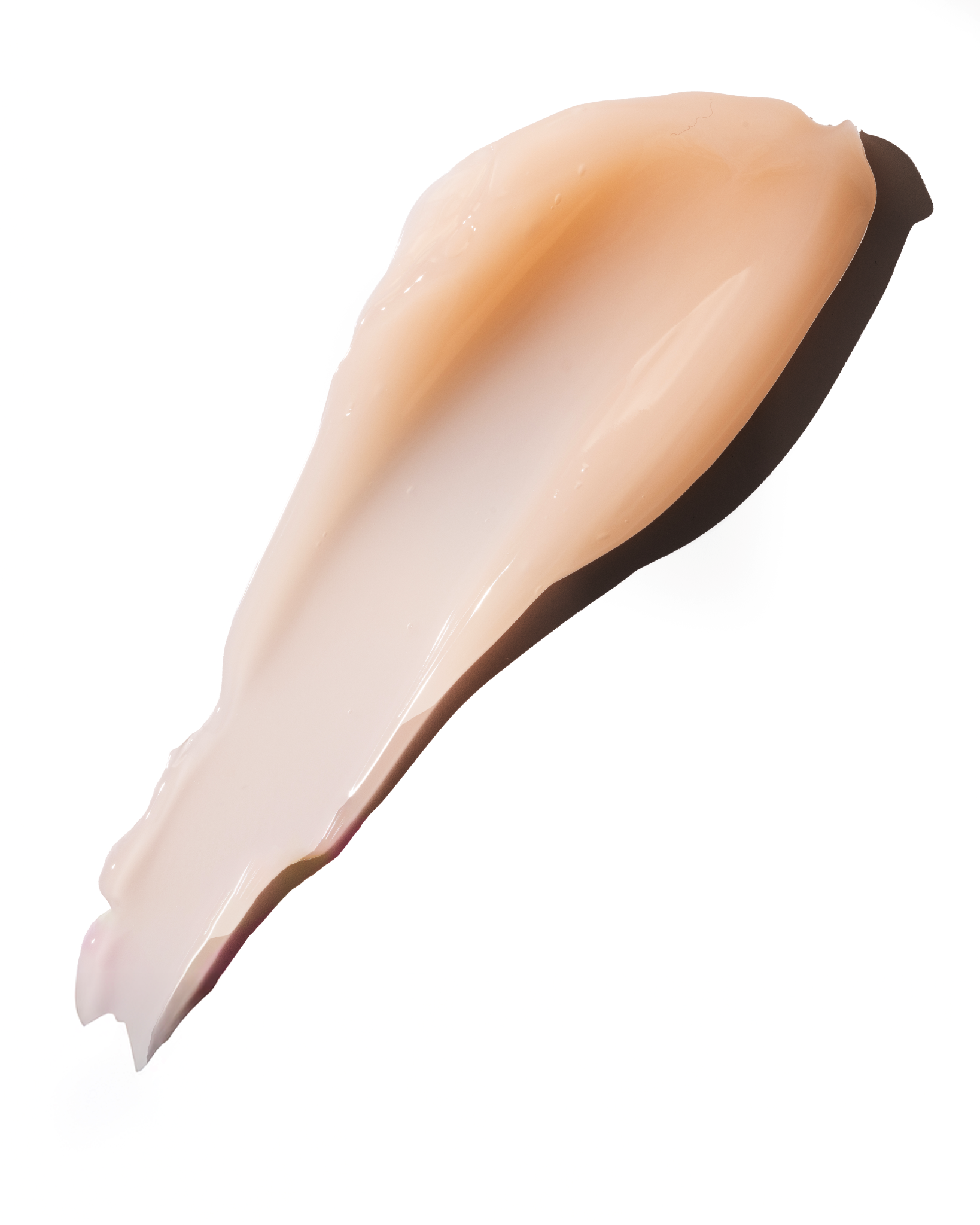 A thick, glossy smear of light peach-beige cream or gel makeup swatch on a solid white background.