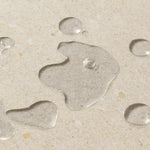 Close up of clear liquid on a beige background